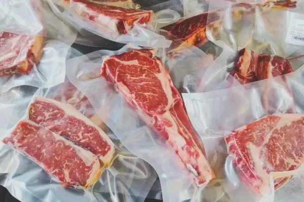 Das Bild zeigt mehrere marmorierte Stücke Fleisch verpackt in Dry Aging Beuteln.