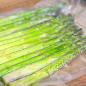 Grüner Spargel welcher in einem strukturierten Vakuumbeutel vakuumiert wurde.